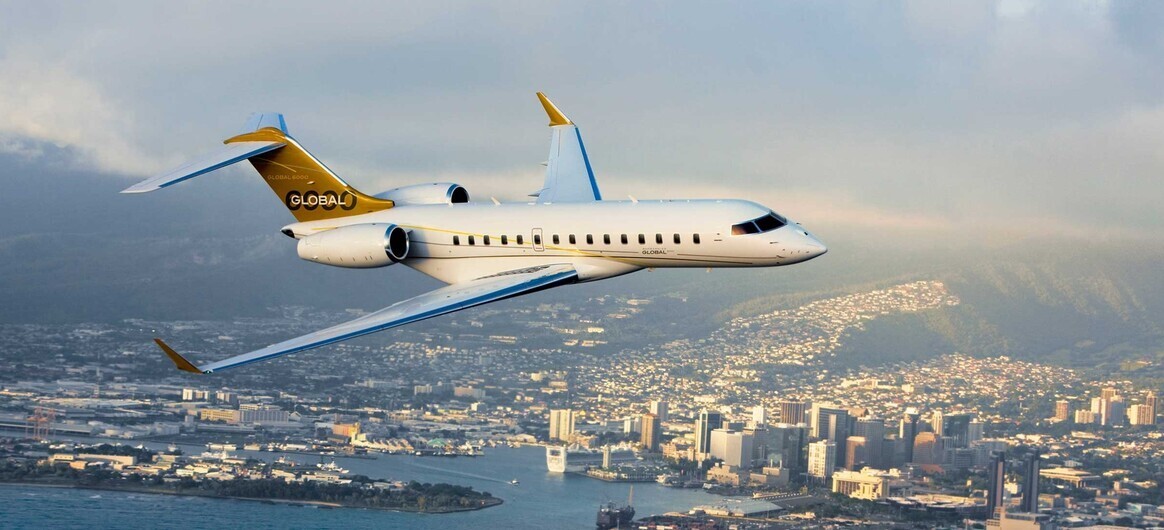 Bombardier Global 6000 flying over city