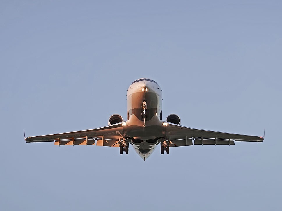 Large cabin private jet flying overhead