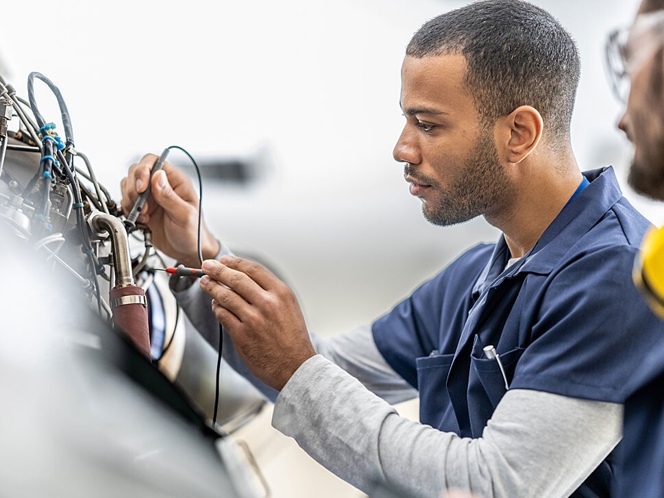 Private jet mechanics work on an aircraft engine